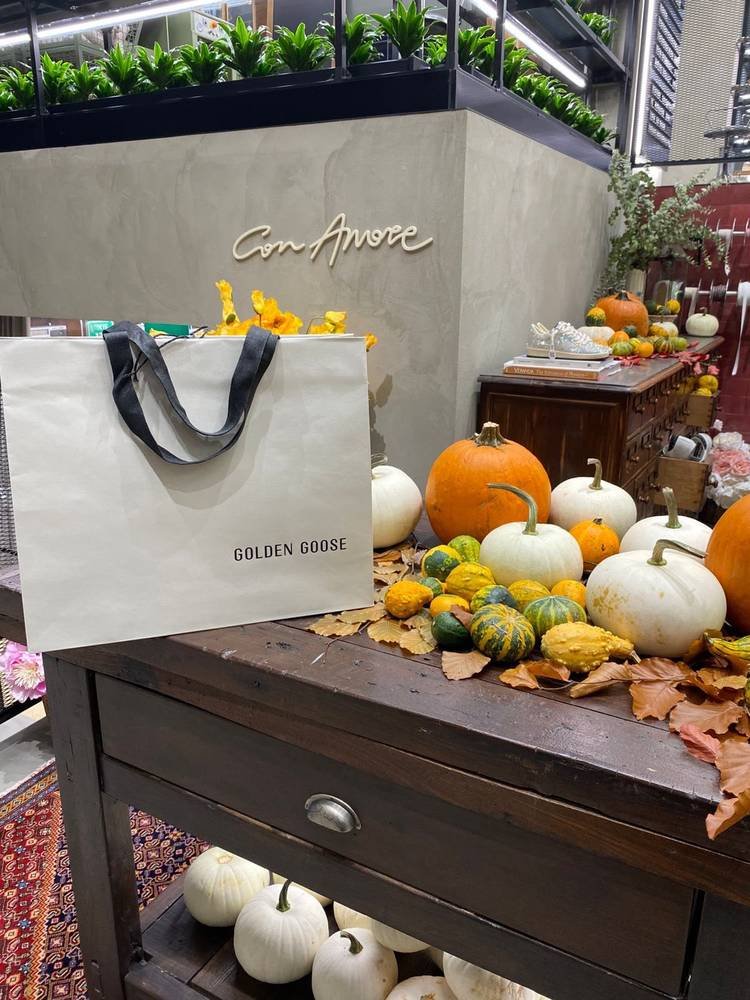 Bolsa de compras sobre una mesa decorada con calabazas